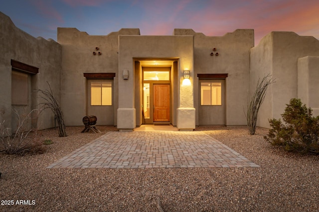 exterior entry at dusk with a patio