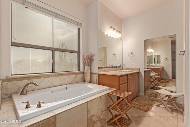 bathroom with vanity, tile patterned flooring, a wealth of natural light, and tiled bath