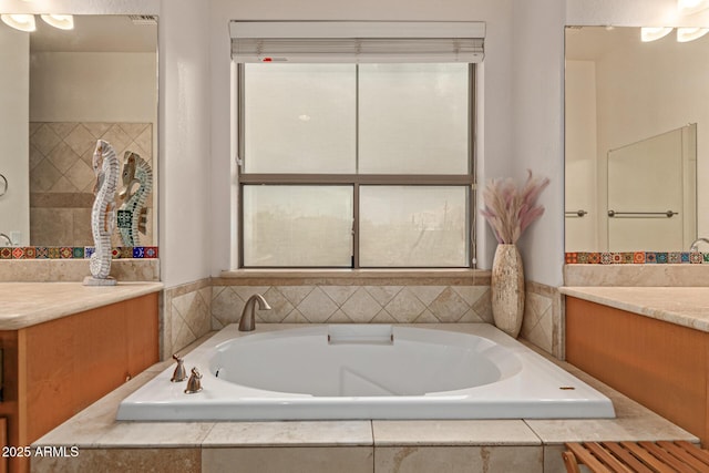 bathroom with vanity, a wealth of natural light, and tiled bath