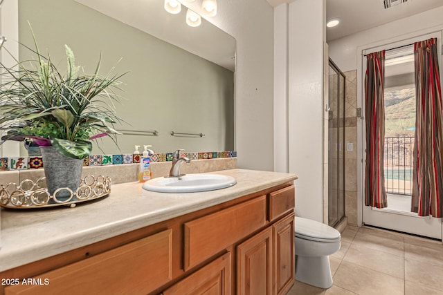 bathroom featuring vanity, a wealth of natural light, tile patterned floors, and toilet