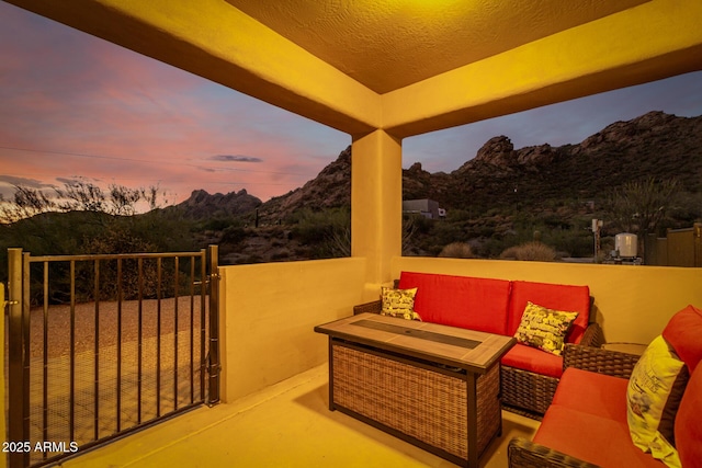 patio terrace at dusk with a mountain view and an outdoor hangout area