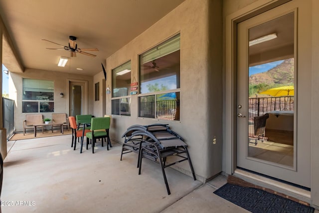 view of patio with ceiling fan and a mountain view