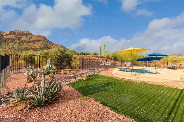 view of yard with a fenced in pool, a mountain view, and a patio area