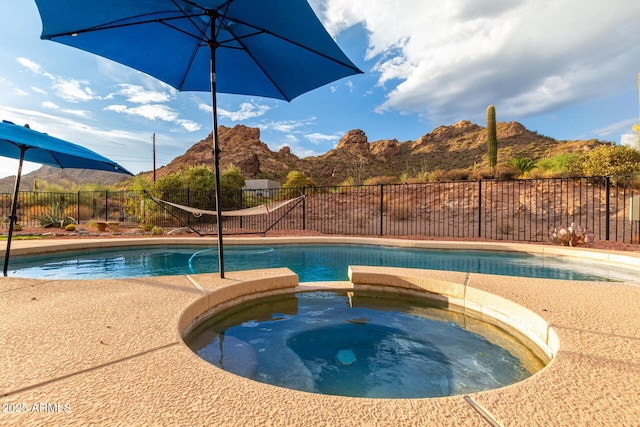 view of swimming pool featuring an in ground hot tub and a mountain view