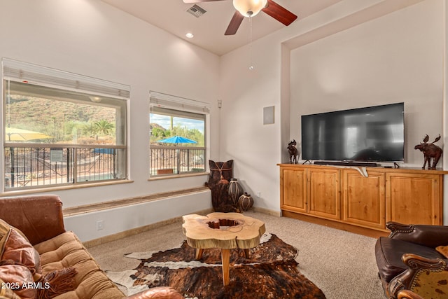 living room featuring light colored carpet and ceiling fan