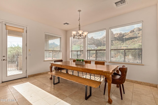 tiled dining space with a chandelier