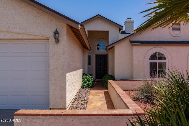 4313 E Briarwood Ter, Phoenix, AZ 85048 - view of exterior entry with stucco siding, a garage, and a chimney