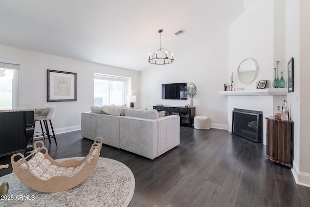 4313 E Briarwood Ter, Phoenix, AZ 85048 - living area with baseboards, a chandelier, dark wood finished floors, a fireplace, and lofted ceiling