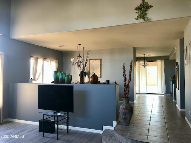 interior space with visible vents, baseboards, and a notable chandelier