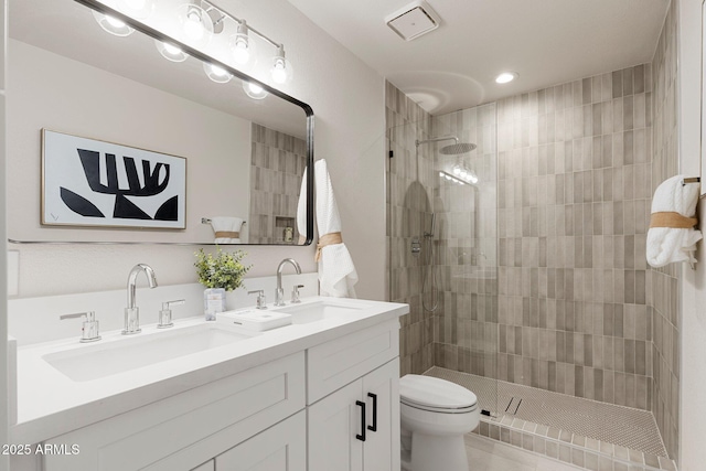 bathroom with double vanity, walk in shower, a sink, and toilet