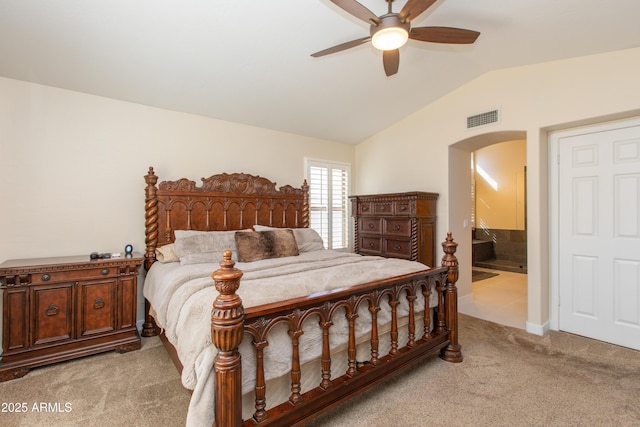 carpeted bedroom with ceiling fan, lofted ceiling, and connected bathroom