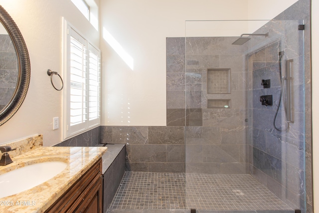 bathroom with tiled shower and vanity