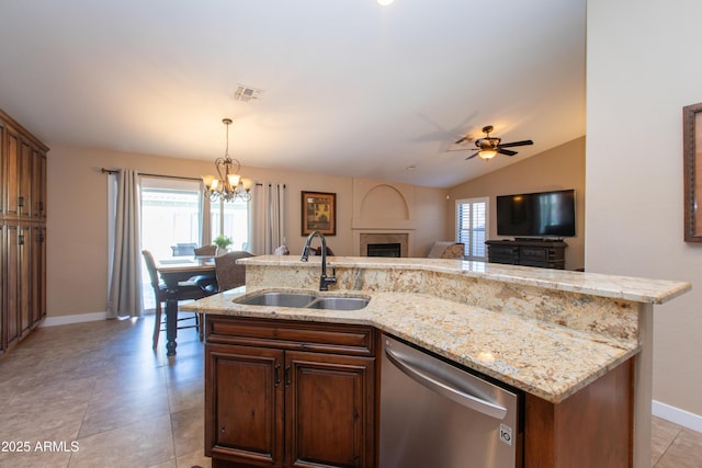 kitchen featuring an island with sink, stainless steel dishwasher, lofted ceiling, ceiling fan with notable chandelier, and sink