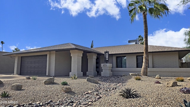 6620 E Paradise Ln, Scottsdale, AZ 85254 - view of front of home featuring brick siding, an attached garage, driveway, and roof with shingles