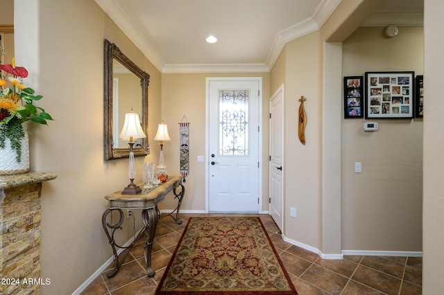 foyer featuring baseboards, dark tile patterned flooring, and crown molding