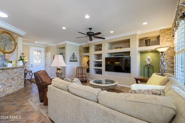 living area with built in shelves, a ceiling fan, crown molding, and recessed lighting