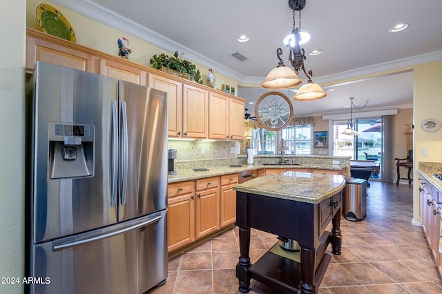 kitchen featuring crown molding, visible vents, a sink, stainless steel fridge, and a peninsula