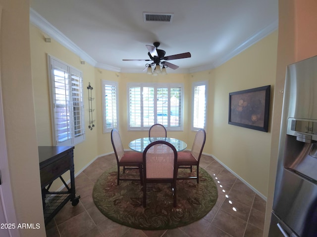 dining space with visible vents, ornamental molding, baseboards, and dark tile patterned flooring