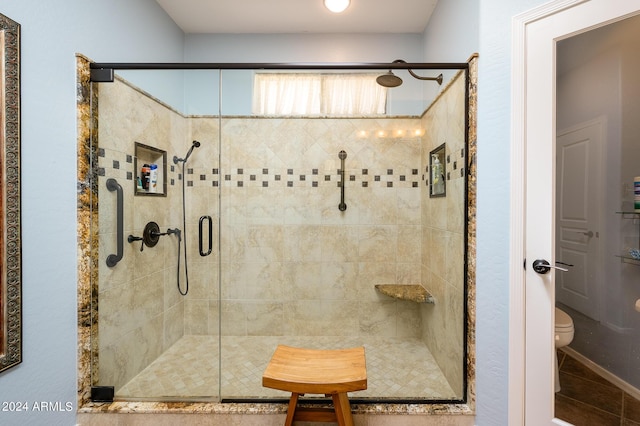 bathroom featuring a stall shower, tile patterned flooring, and toilet