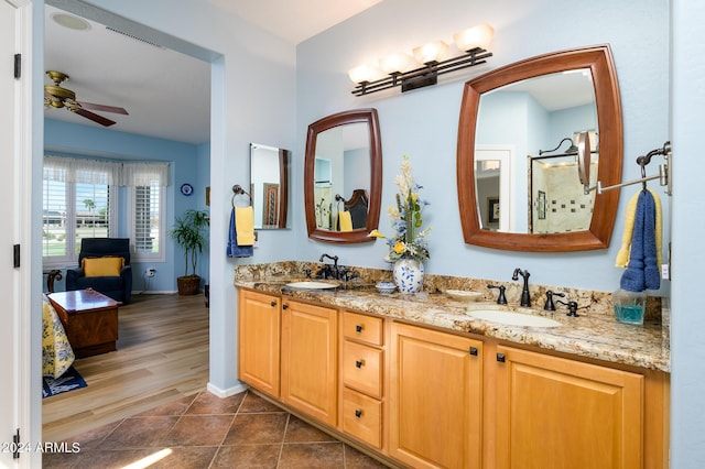 bathroom featuring double vanity, ceiling fan, a sink, and tile patterned floors