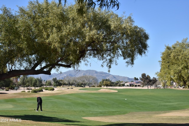 surrounding community featuring view of golf course, a lawn, and a mountain view