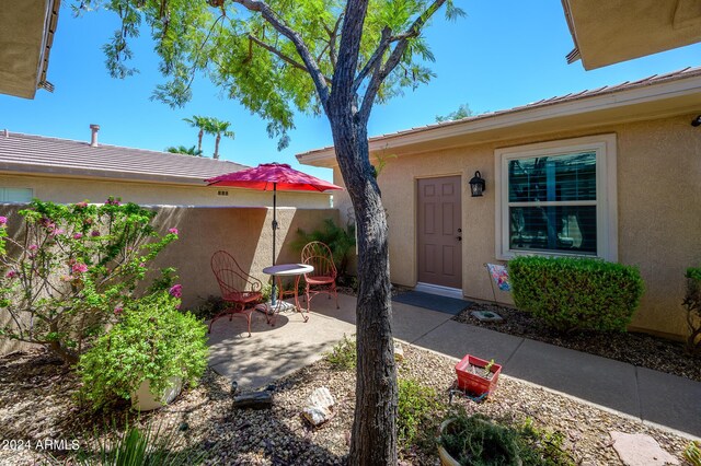 view of exterior entry with a patio area