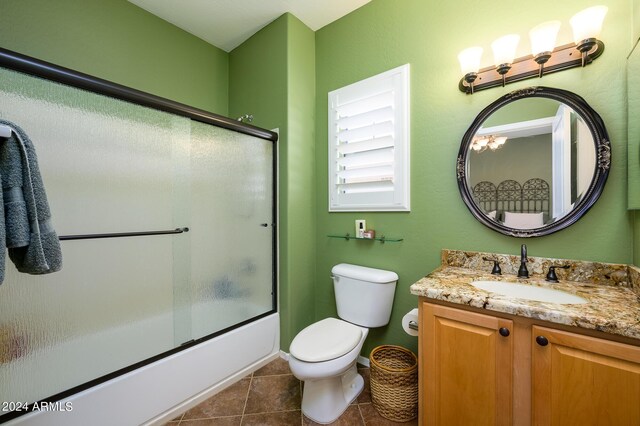 full bathroom with vanity, shower / bath combination with glass door, toilet, and tile patterned floors