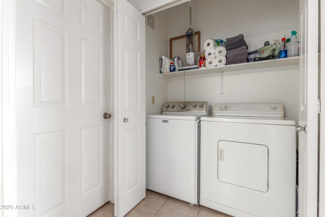 laundry room with independent washer and dryer and light tile patterned floors