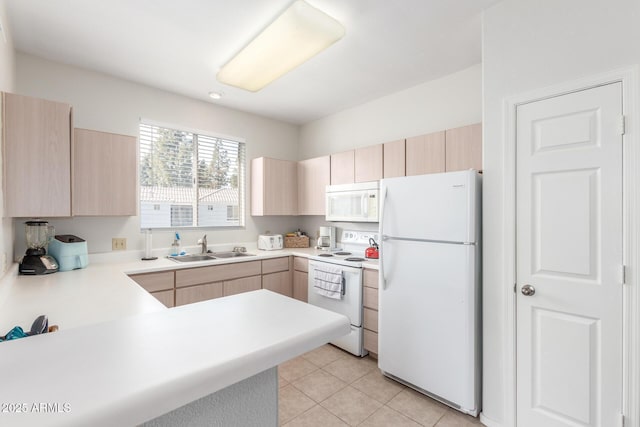 kitchen featuring kitchen peninsula, light brown cabinets, white appliances, and sink