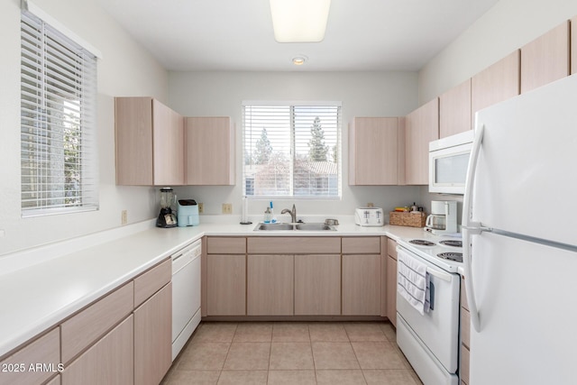 kitchen with light brown cabinets, white appliances, sink, and light tile patterned floors