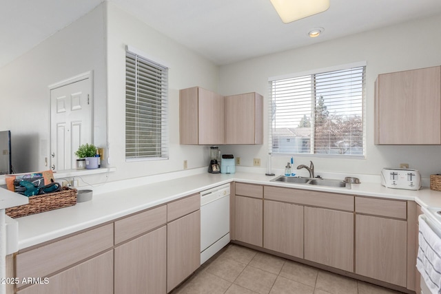 kitchen featuring sink, white dishwasher, light tile patterned floors, and light brown cabinets