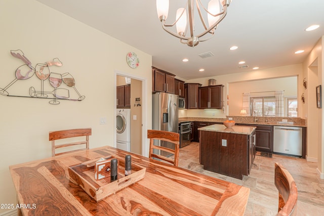 dining room with washer / clothes dryer, a notable chandelier, and sink