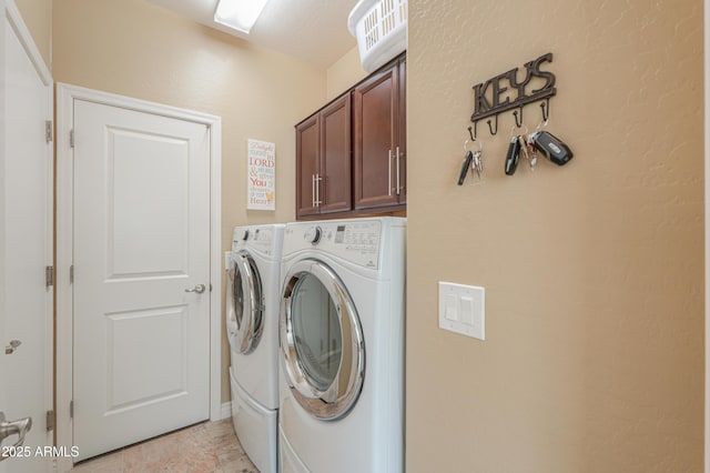 laundry area with separate washer and dryer and cabinets