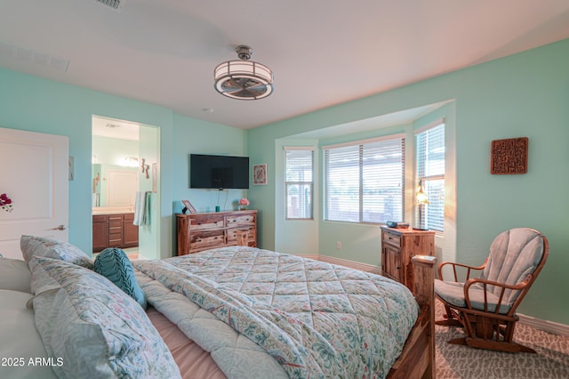 bedroom featuring ensuite bath and hardwood / wood-style floors