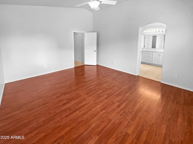 empty room featuring ceiling fan, vaulted ceiling, and light wood-type flooring