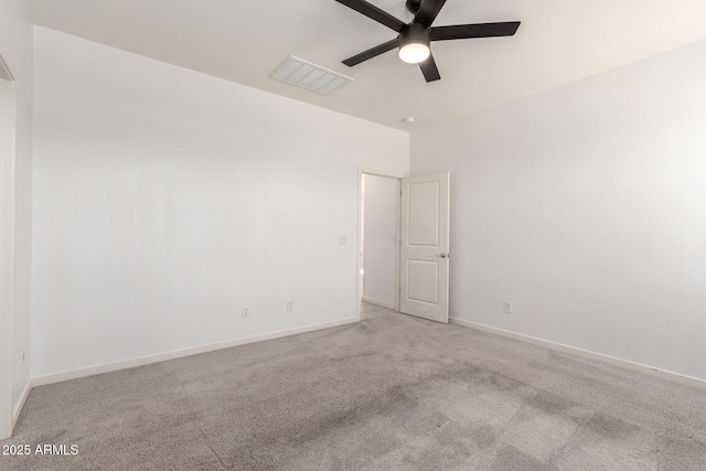 carpeted empty room featuring baseboards, visible vents, and ceiling fan