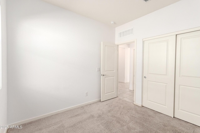 unfurnished bedroom with a closet, visible vents, baseboards, and carpet