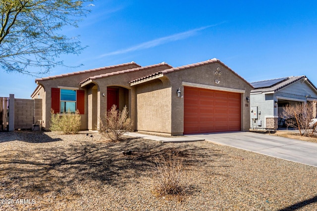 view of front of home featuring stucco siding, fence, concrete driveway, a garage, and a tiled roof