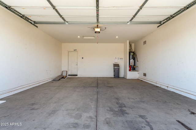 garage with water heater, visible vents, and a garage door opener