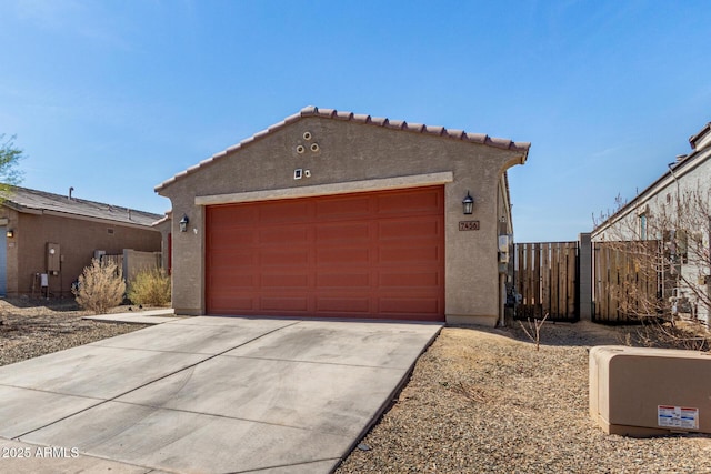 garage featuring driveway and fence