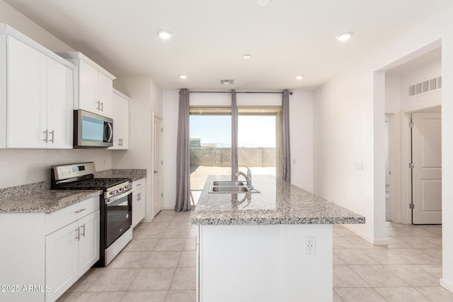 kitchen featuring visible vents, a sink, recessed lighting, stainless steel appliances, and a kitchen island with sink