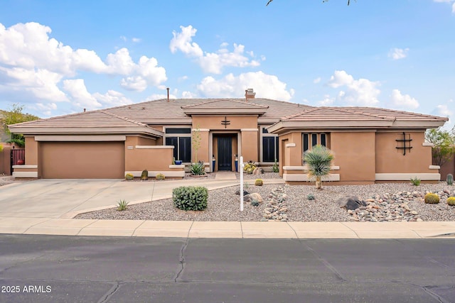 view of front of house with a garage, concrete driveway, and stucco siding