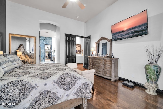 bedroom featuring arched walkways, ceiling fan, baseboards, and wood finished floors