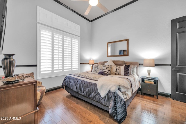 bedroom with wood-type flooring, a ceiling fan, and crown molding