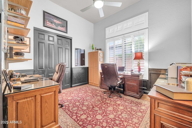 office area featuring ceiling fan and wainscoting