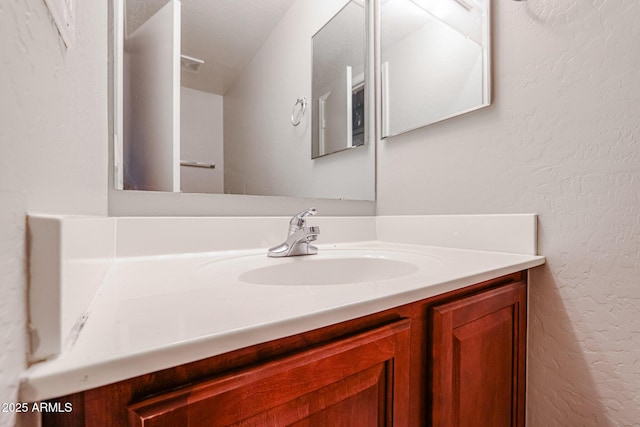 bathroom featuring vanity and a textured wall