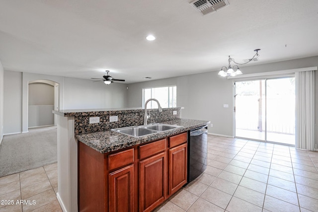 kitchen with light tile patterned floors, visible vents, an island with sink, a sink, and black dishwasher