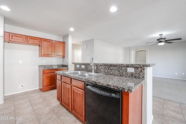 kitchen featuring brown cabinetry, light tile patterned flooring, an island with sink, a sink, and black dishwasher