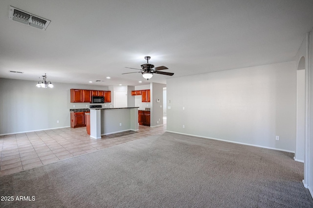 unfurnished living room featuring visible vents, baseboards, light colored carpet, ceiling fan with notable chandelier, and light tile patterned flooring