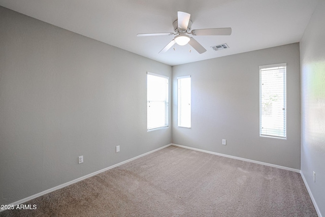 unfurnished room featuring a ceiling fan, visible vents, carpet floors, and baseboards